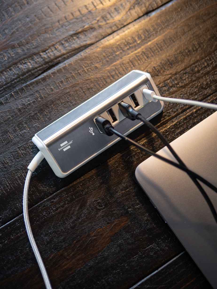 brennenstuhl® estilo Mehrfach-USB-Ladestation mit mehreren USB-Anschlüssen und modernem Design, auf der Ladestation liegende Kabel